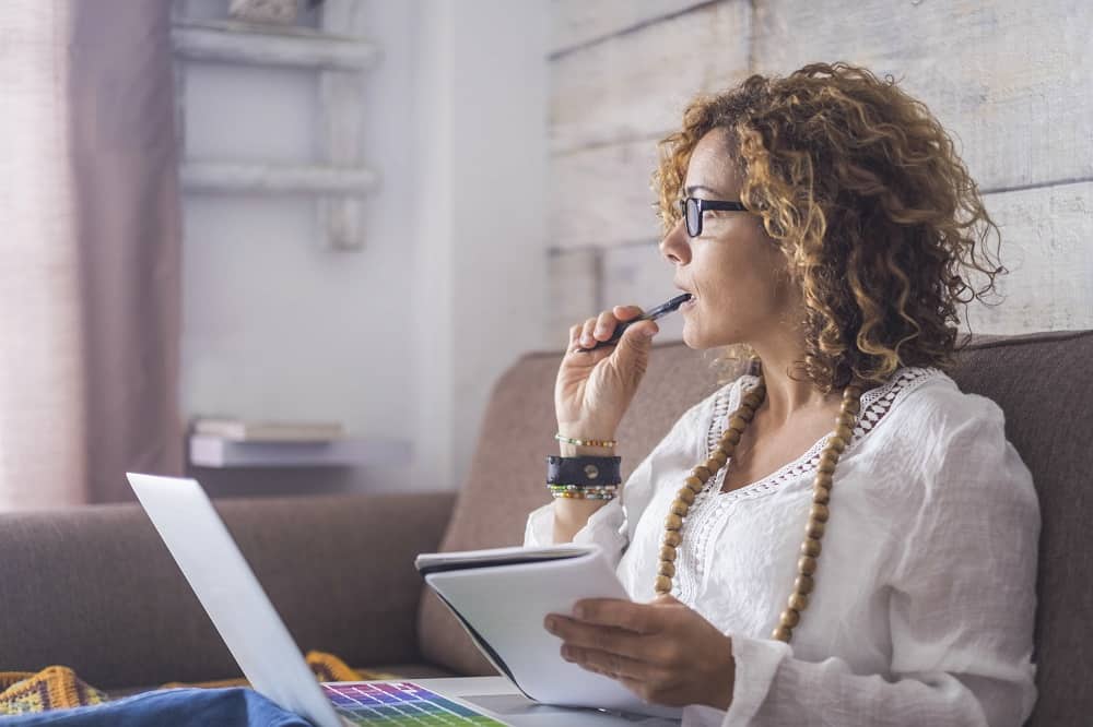 Women sitting on couch with laptop, notebook and pen